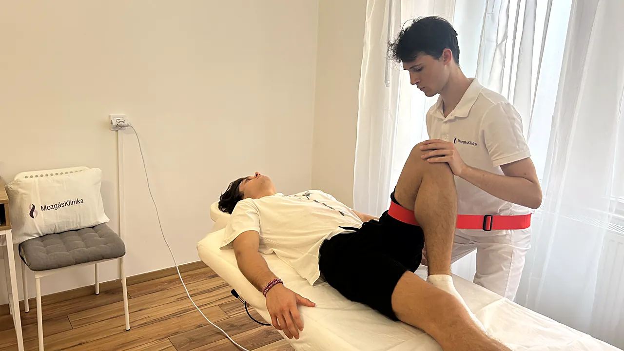 Csípőmobilizáció hevederrel a kezelőágyon