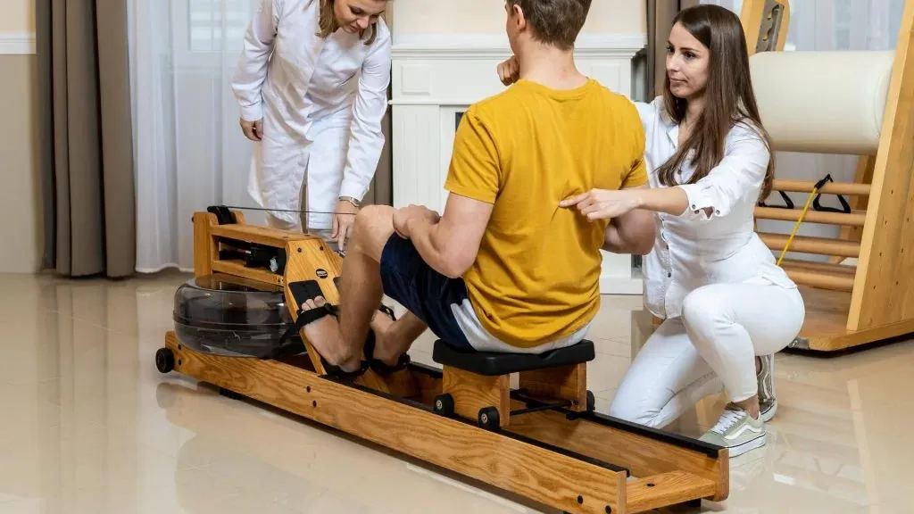 Evezőgépes edzés két gyógytornász irányításával